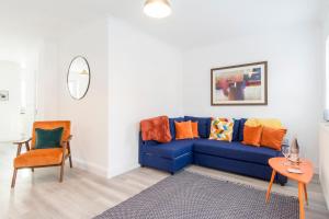 a living room with a blue couch and a table at Charming 3- Bedroom Terrace House with Netflix and Free Parking by HP Accommodation in Market Harborough