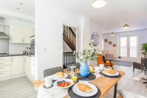 a kitchen and dining room with a table with food on it at Charming 3- Bedroom Terrace House with Netflix and Free Parking by HP Accommodation in Market Harborough