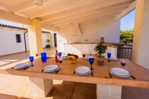 une table dans une cuisine avec des lunettes bleues dans l'établissement Villa Flavia by Villa Plus, à San Vito dei Normanni