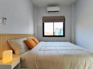 a bedroom with a bed and a window at Baan Trin(บ้านตฤณ) in Chiang Rai