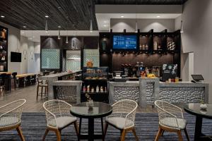 restauracja ze stołami i krzesłami oraz bar w obiekcie Marriott Phoenix Chandler w mieście Chandler