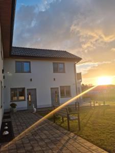 a house with the sunset in the background at Siedem mórz in Gąski