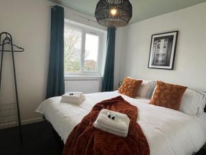 a bedroom with a large bed with towels on it at Harmony House - 4 Doubles, Free Wi-fi, Parking in Walsall