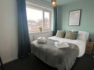 a bedroom with a bed with towels on it at Harmony House - 4 Doubles, Free Wi-fi, Parking in Walsall