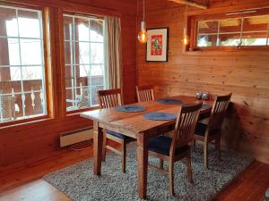 a wooden dining room with a wooden table and chairs at Cosy chalet, 100m2 with fjordview! in Lauvstad