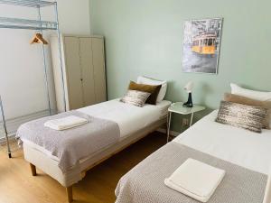 twee bedden in een kamer met een treinfoto aan de muur bij Feel Cascais Center 2bd in Cascais