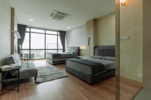 a bedroom with a bed and a couch and a chair at SUMMER SUITES APARTMENT CASETTA HOMESTAY 2 at Kota Samarahan Kuching in Kuching