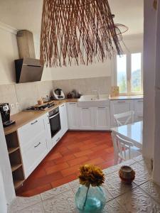 cocina con armarios blancos y suelo de baldosa roja en Superbe villa avec piscine, en LʼEscarène