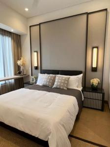 a bedroom with a large bed with white sheets at LUCENTIA KUALA LAMPUR in Kuala Lumpur