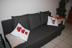 a gray couch with two pillows on it at Schwarzwaldstube 2 Zimmer für Gäste in Vörstetten in Vörstetten