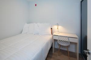 1 dormitorio con 1 cama y escritorio con silla en Micro Boutique Living Fredericton, en Fredericton