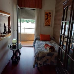 Schlafzimmer mit einem Bett, einem Tisch und einem Fenster in der Unterkunft piso compartido con habitaciones independientes in Cerrillo de Maracena
