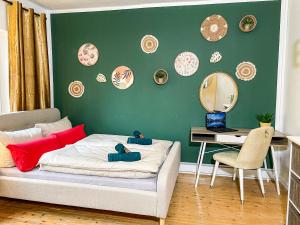 a bedroom with a bed and a green wall with plates at Landhaus beim Knoops Park in Bremen
