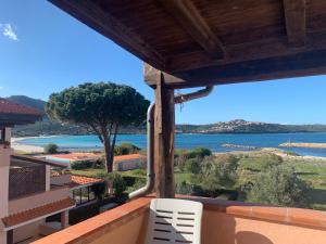 a balcony with two chairs and a view of the water at Sardegna Beach Cala Reale in Santa Marinella