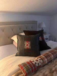 - un lit avec quelques oreillers dans l'établissement Mountaindream Apartment, à Sedrun