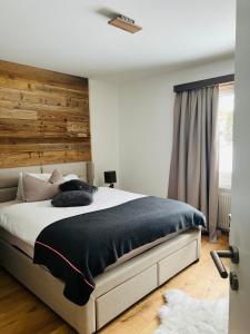 - une chambre avec un grand lit et une tête de lit en bois dans l'établissement Mountaindream Apartment, à Sedrun