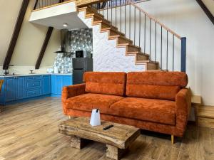 a living room with a brown couch and stairs at Ultra house in Ilʼtsya Gurny