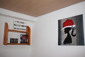 a picture of a woman wearing a hat on a wall at Schwarzwaldstube 2 Zimmer für Gäste in Vörstetten in Vörstetten
