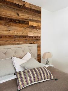 - une chambre avec un mur en bois et un lit dans l'établissement Mountaindream Apartment, à Sedrun