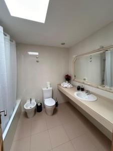 uma casa de banho com um WC, um lavatório e um espelho. em Casa Orquídea em Puerto del Rosario
