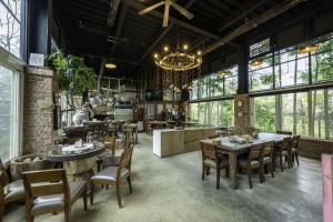 a dining room with tables and chairs and windows at SeeU Coffee and B&B in Xihu