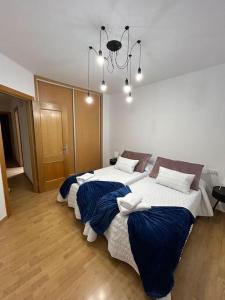 2 camas num quarto com um lustre em Casa Orquídea em Puerto del Rosario