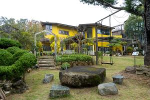 una casa amarilla con una gran roca delante de ella en SeeU Coffee and B&B, en Xihu