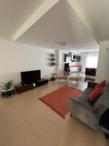 uma sala de estar com um sofá cinzento e um tapete vermelho em Casa Orquídea em Puerto del Rosario
