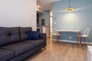 sala de estar con sofá y mesa en Micro Boutique Living Fredericton, en Fredericton