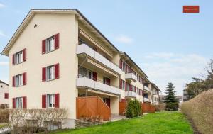 an apartment building with red windows and a yard at Charming Apartment in Zurich in Zurich