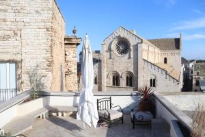 比通托Terrazza Romanelli Suites的一个带遮阳伞和教堂的庭院