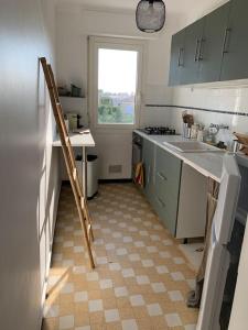une cuisine avec une échelle au milieu d'une cuisine dans l'établissement Cyrille Besset - Charmant T2 avec balcon, à Cagnes-sur-Mer
