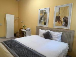um quarto com uma cama com duas fotografias na parede em PensionLien em Köthen
