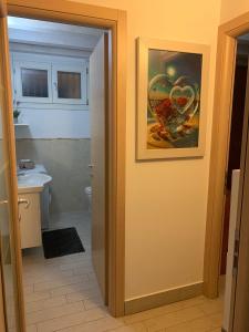 a bathroom with a painting of a heart on the wall at Casa Antico Barbiere in Chioggia