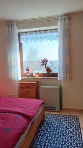a bedroom with a bed and a window with a rooster in the window at Appartment 142 in Tossens in Butjadingen OT Tossens