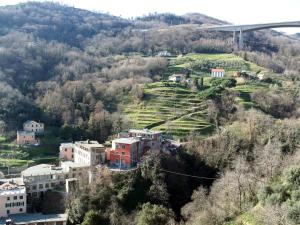 un village sur une colline avec des maisons et un pont dans l'établissement Casa Clo' by Holiday World, à Gênes