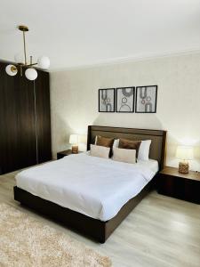 1 dormitorio con 1 cama grande con sábanas y almohadas blancas en Apartament Natymar2 en Adjud