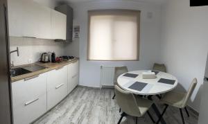 uma cozinha com mesa e cadeiras num quarto em Apartament Natymar2 em Adjud