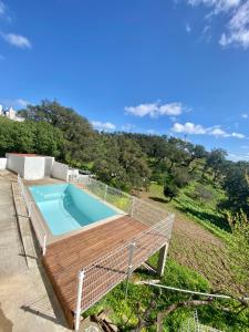 una piscina en la parte superior de una terraza con una terraza de madera en Casa Ti Barbara 