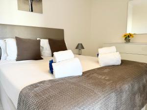 een slaapkamer met een groot bed met witte kussens bij Apartment Algarve - Beach Front - Free Wifi - Air Con in Armação de Pêra