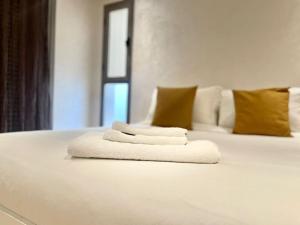 2 serviettes blanches assises au-dessus d'un lit dans l'établissement Villa anfa 3, à Casablanca