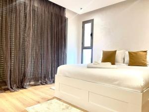 - un lit blanc dans une chambre avec fenêtre dans l'établissement Villa anfa 3, à Casablanca