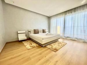 een slaapkamer met een wit bed en een groot raam bij Villa anfa 3 in Casablanca
