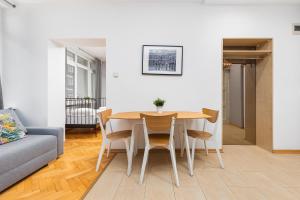 a living room with a table and chairs and a couch at Apartament Wspólna by Your Freedom in Warsaw