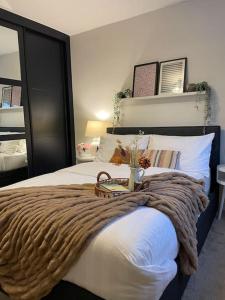 a bedroom with a bed with a blanket on it at Charming Family Home with Gym in Henley on Thames