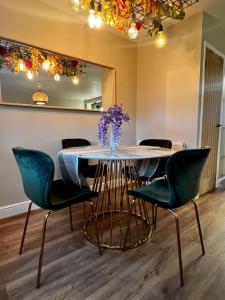 a table with chairs and a vase of flowers on it at Charming Family Home with Gym in Henley on Thames