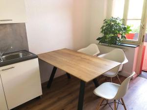 cocina con mesa de madera y sillas blancas en Apartment in Innenstadt Bielefeld, en Bielefeld