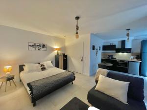 a bedroom with a bed and a couch at APPART'ICI 2 - Spacieux studio in Lunel-Viel
