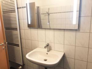 een witte badkamer met een wastafel en een spiegel bij Apartment in Innenstadt Bielefeld in Bielefeld