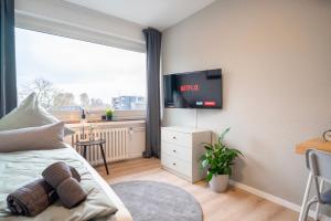 1 dormitorio con 1 cama y TV en la pared en Juno - #1 Terrassen-Apartment, Netflix, WLAN, en Bottrop